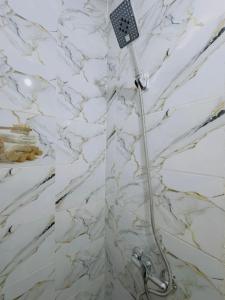 a shower in a bathroom with a white marble wall at Julie Airport Boarding Apartment in Marrakech +11 photos