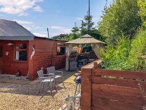 a house with a patio with a table and an umbrella at Cow Boy Cabin - Uk47145 in Glasgow