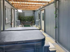 a covered patio with a table and chairs and a mattress at Cow Boy Cabin - Uk47145 in Glasgow
