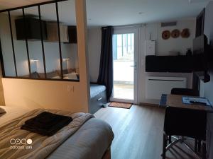 a room with a bed and a table and a mirror at Aux pieds de la colline de Mousson in Pont-à-Mousson