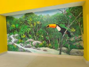 a large painting of a bird on a wall at Pousada Beira Mar Peruíbe in Peruíbe +68 photos
