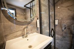 Un baño con lavabo y ducha con espejo. en Marlen Hotel Mavisehir, en Izmir 69 fotos más