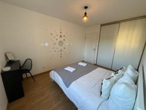 - une chambre avec un lit et un mur avec une horloge dans l'établissement Les Reflets de Dijon, à Dijon