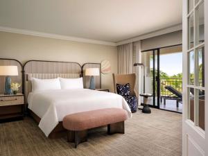 a bedroom with a large bed and a balcony at Fairmont Orchid in Waikoloa