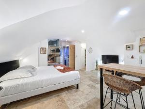 a bedroom with a bed and a wooden table at Love Room Beaumont Sauna et Balnéo in Beaumont
