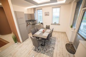a kitchen and dining room with a table and chairs at Fehér Akác Wellness Vendégház in Nyíradony
