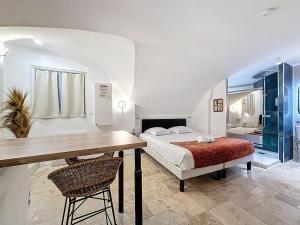 a bedroom with a bed and a desk and a table at Love Room Beaumont Sauna et Balnéo in Beaumont