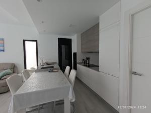 a white table and chairs in a white kitchen at Casa Kempie in San Javier