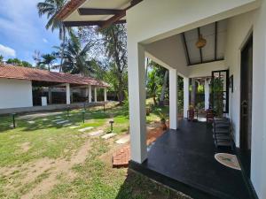 a front porch of a house with a yard at Charitha Rest in Ampara