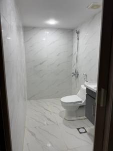 une salle de bain blanche avec toilettes et lavabo dans l'établissement Wadi Rum CAMP, à Disah