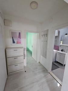 Habitación blanca con vestidor blanco y baño. en Mostar Luxury Apartment, en Mostar
