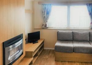 ein Wohnzimmer mit Couch und Fernseher in der Unterkunft Towervans Caravan Park in Mablethorpe + 21 Fotos
