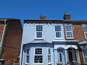 滨海戈尔斯顿Cosy Pet Friendly Holiday House in Gorleston - five minutes to beach的一栋带有砖砌建筑的蓝色大房子