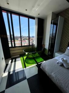 a bedroom with a bathroom with a tub and a window at Modern Sueno Lux Apartments in Tirana