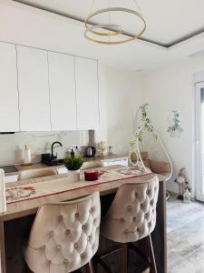 a kitchen with white cabinets and a table with chairs at pappy home in Pasuljište