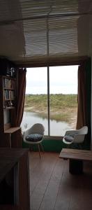 a view of a room with two chairs and a window at Casa Campo in Cufré
