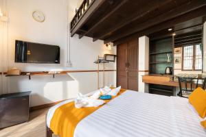 a bedroom with a large bed with a tv on the wall at Arun Sa Wad 103 NaNa in Bangkok