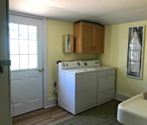 a small kitchen with a white washer and a window at UP Cottage in Saint Ignace +33 photos