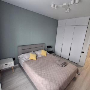 une chambre avec un grand lit avec des oreillers jaunes dans l'établissement Квартира в Рівному біля луцького кільця, à Rivne