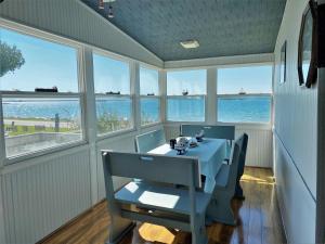 a dining room with a table and chairs and the ocean at Serendipity in Saint Ignace