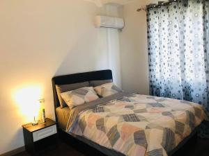 a bedroom with a bed and a table with a lamp at Family 