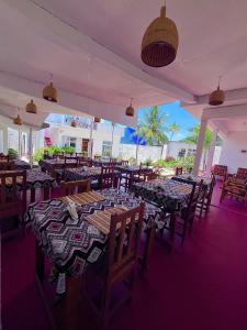 a dining room with tables and chairs at Karibu House Paje in Paje