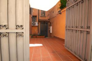 Un callejón con paredes naranjas y puertas de metal. en Blue Goose Apartment, en Ronciglione