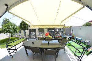 a patio with a table and chairs under a tent at Vila Rares in Costinesti