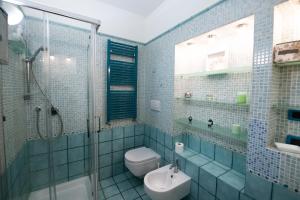 y baño de azulejos azules con aseo y ducha. en Blue Goose Apartment, en Ronciglione 21 fotos más