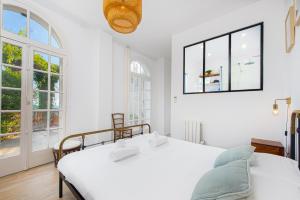 マントンにあるMenton Garavan, paradis face a la merの窓が2つある部屋にベッドが2つある