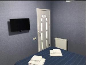1 dormitorio con 1 cama, TV y puerta en apart hotel at sea, en Itʼkhvisi