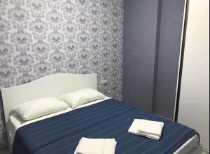 una habitación azul y blanca con una cama con dos almohadas en apart hotel at sea, en Itʼkhvisi