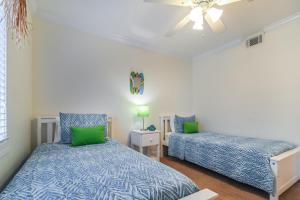 Un dormitorio con dos camas y un ventilador de techo. en Sea Sight Villa B, en Tybee Island