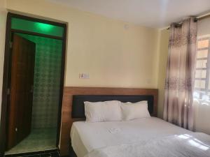 a bedroom with a bed and a glass shower at Kim's Executive Three bedroom apartment with outdoor, Nakuru CBD in Nakuru