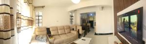 a living room with a couch in a room at Kim's Executive Three bedroom apartment with outdoor, Nakuru CBD in Nakuru