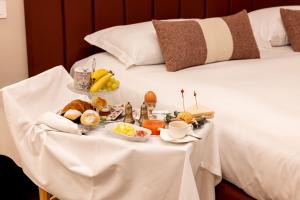 een dienblad met eten op een tafel op een bed bij La Maison de Ville & Suite in Piacenza +95 foto's