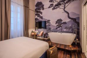 een slaapkamer met een bed en een bad bij La Maison de Ville & Suite in Piacenza