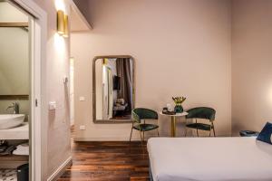 een slaapkamer met een bed, een spiegel en een tafel bij La Maison de Ville & Suite in Piacenza