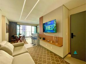 a living room with a couch and a tv on the wall at Beach Class Meireles by Holiday Stays in Fortaleza