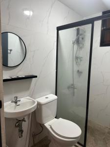 a bathroom with a toilet and a sink and a shower at D'ELEMENTS HOTEL AND DORMITORY in Laoag +34 photos