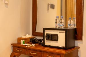 a microwave on a table with bottles of water at Adi s Private Villa in Sukawati