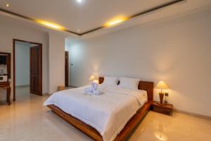 a bedroom with a bed with a teddy bear on it at Adi s Private Villa in Sukawati