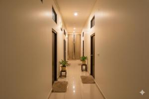 a hallway with two chairs and two plants at Hotel Jayaditya Palace Near Ram Mandir in Ayodhya
