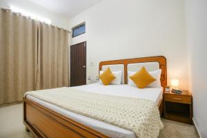 a bedroom with a large bed with yellow pillows at Hotel Jayaditya Palace Near Ram Mandir in Ayodhya +16 photos