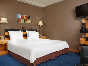 a large white bed in a hotel room at Swissôtel Amsterdam in Amsterdam
