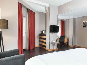 a hotel room with a bed and a television at Swissôtel Amsterdam in Amsterdam +144 photos