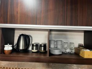 a shelf with cups and plates and a coffee maker at Duplex 2 Villa Ramallo in Estación Ramallo