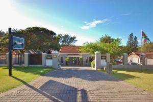 a building with a gate and a brick driveway at Fourteenth Green Guest Lodge in East London