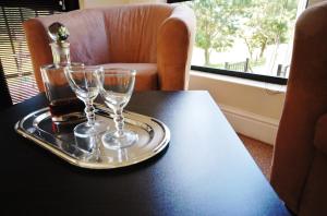 a tray with two wine glasses and a bottle on a table at Fourteenth Green Guest Lodge in East London