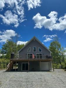 a house with a balcony and an american flag on it at Chalet Montelago in The Hideout in Lake Ariel
